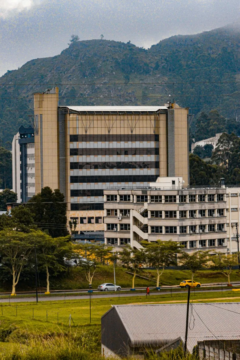The Central Bank of Eswatini headquarters rising above Mbabane, with a fuel station and homes below